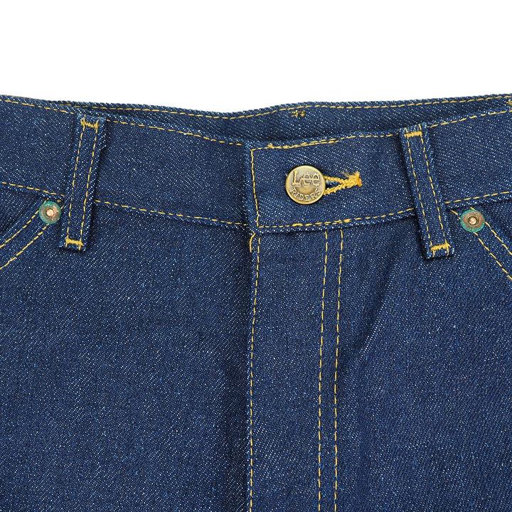 Close-up of raw indigo denim jeans waist area with a branded 'Lee Riders' button.
