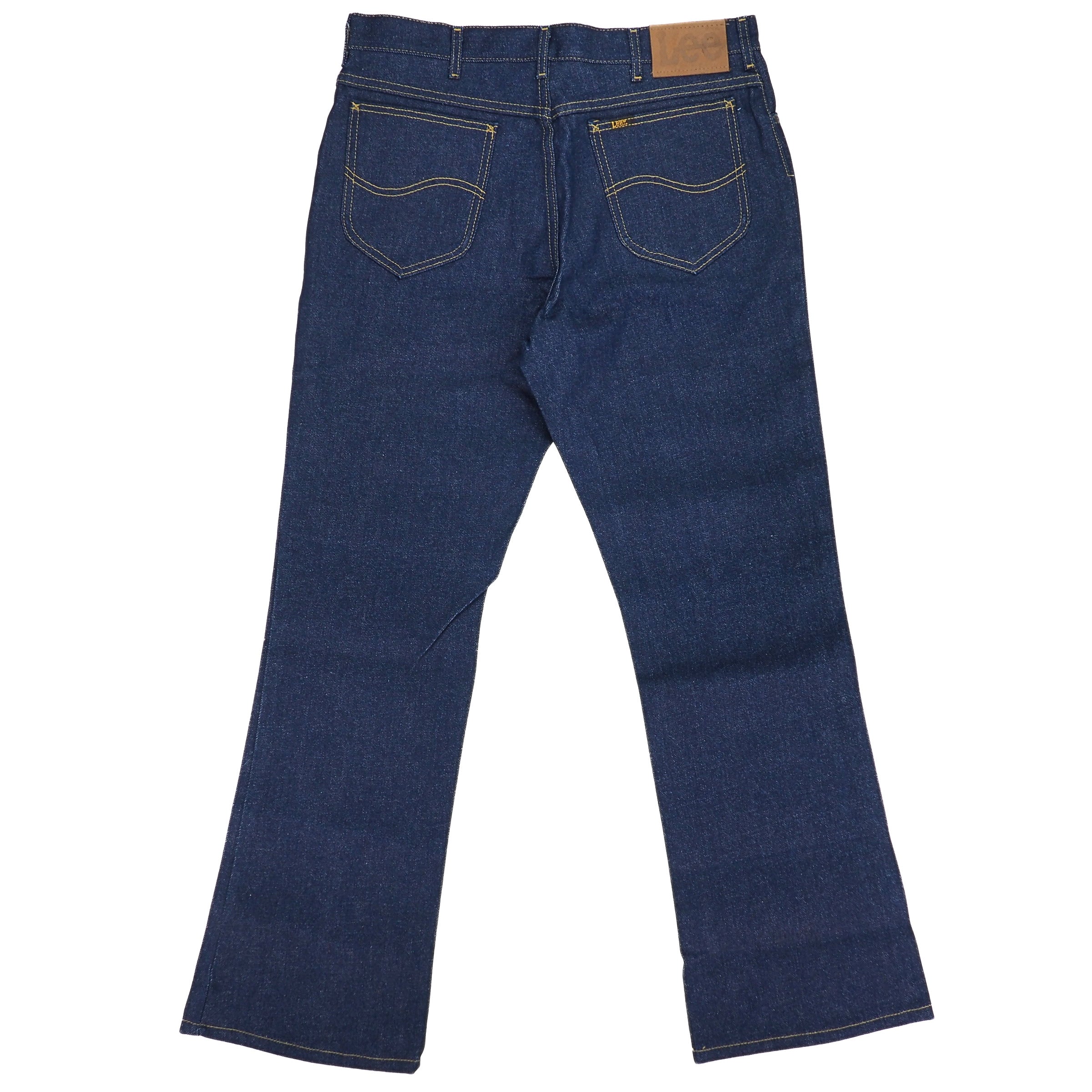 Rear view of a pair of raw indigo denim jeans on a white background