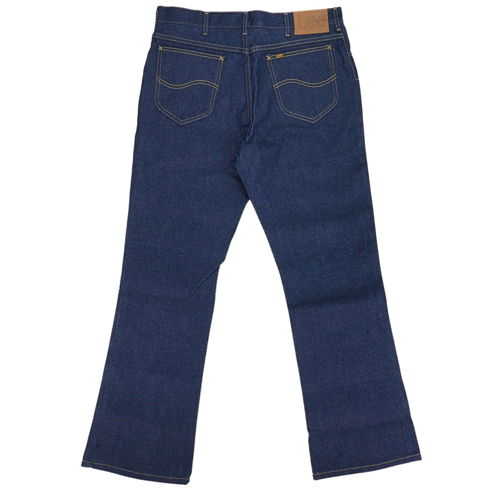 Rear view of a pair of raw indigo denim jeans on a white background