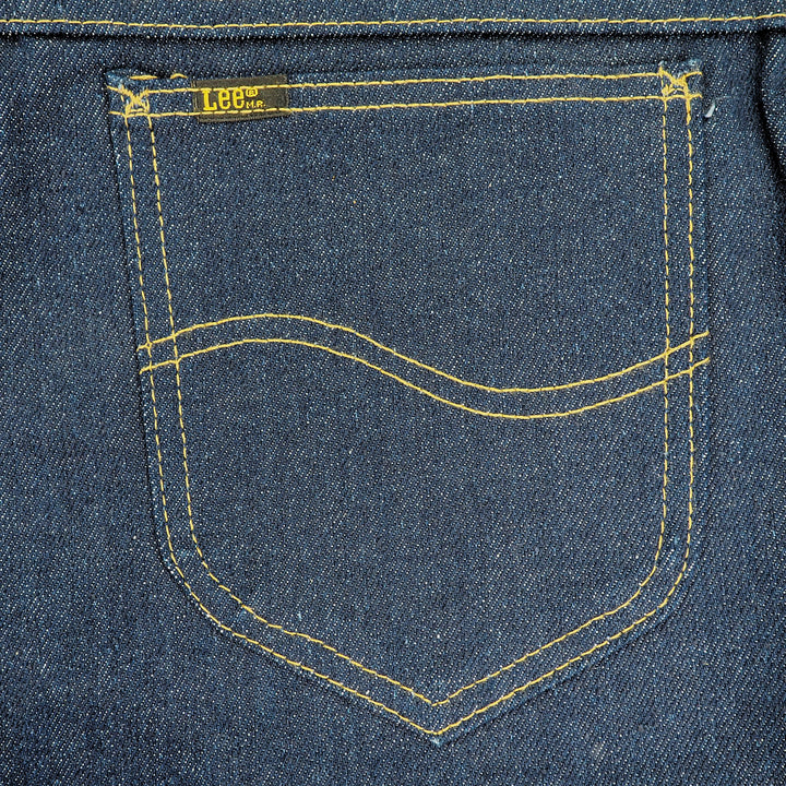 Close-up of a blue denim jean pocket with yellow stitching and a 'Lee' brand label.