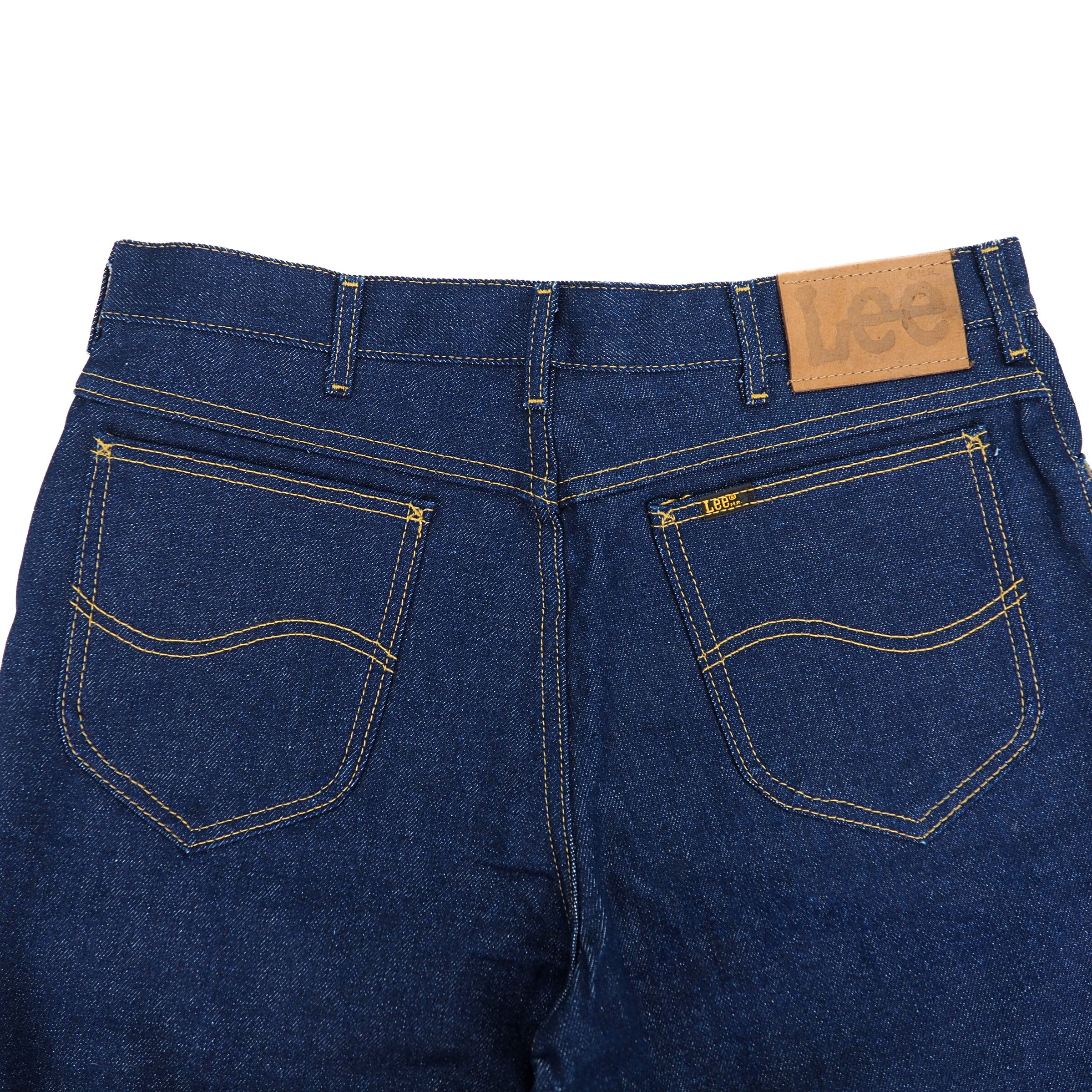 Back view of blue jeans with a brown leather 'Lee' jacron patch on a white background