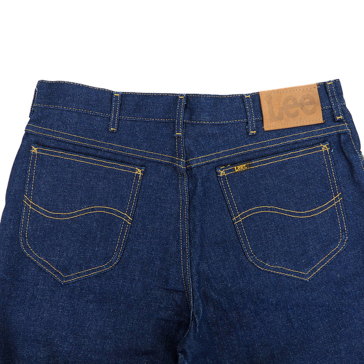 Back view of blue jeans with a brown leather 'Lee' jacron patch on a white background