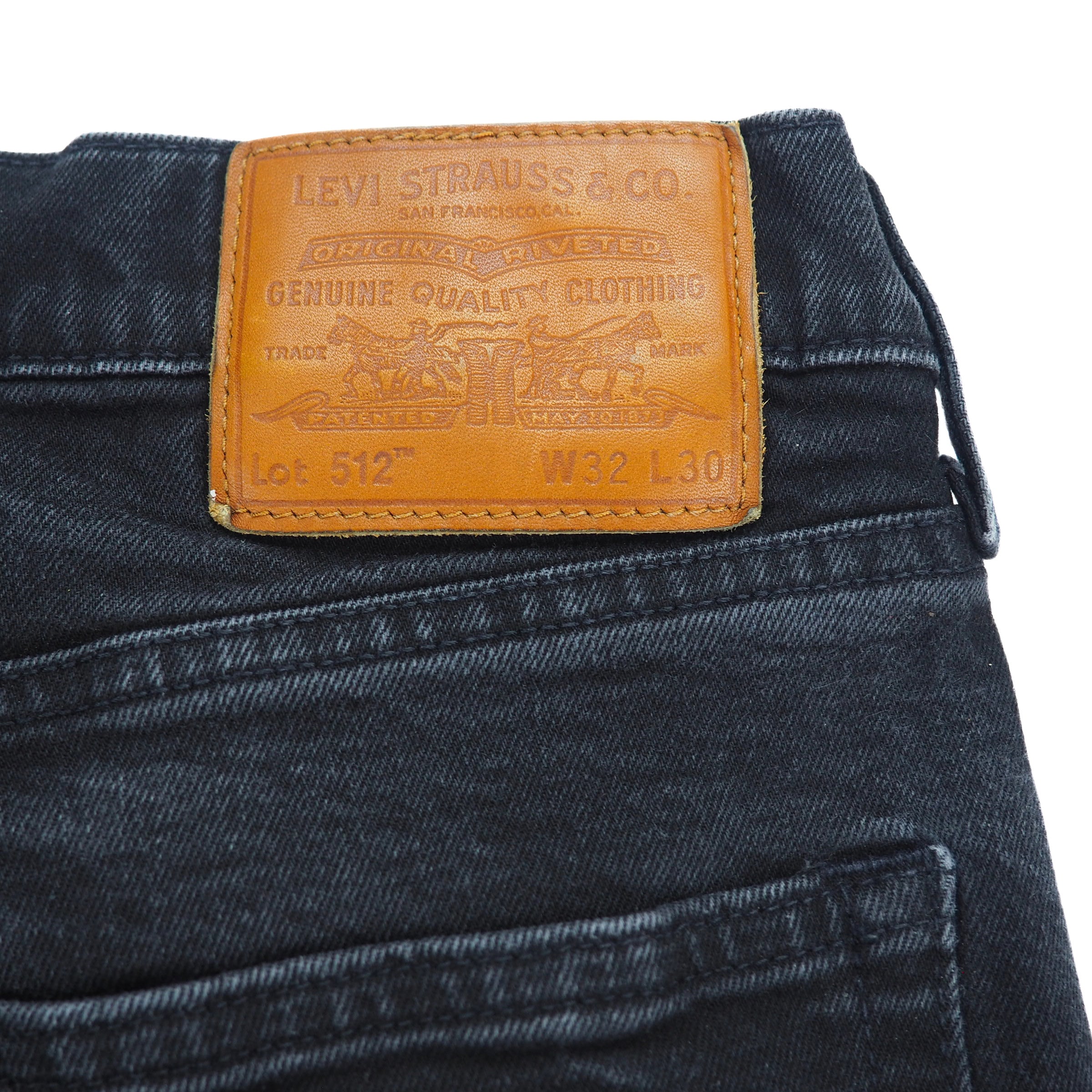 Black Levi's Lot 512 jeans with a brown leather jarcon patch on a white background