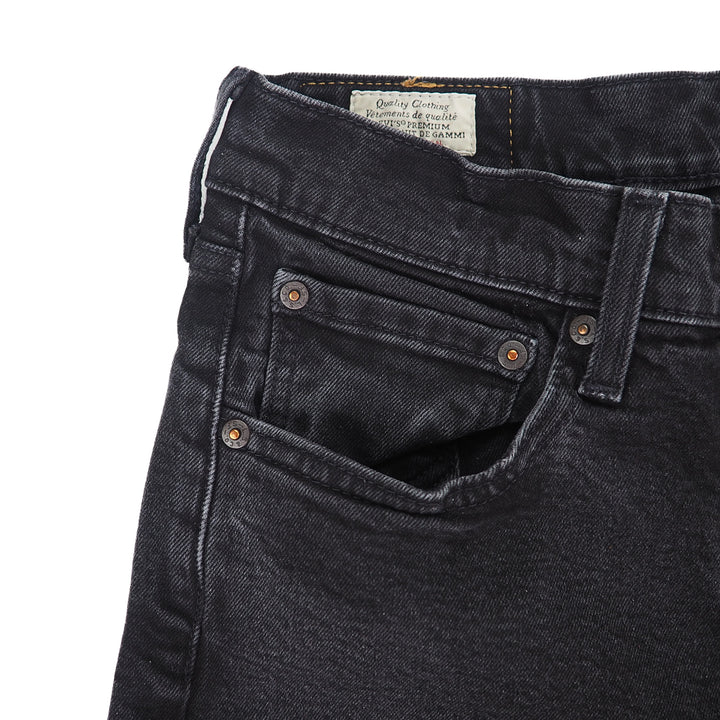 Close-up of black levis jeans with a visible brand label on a white background