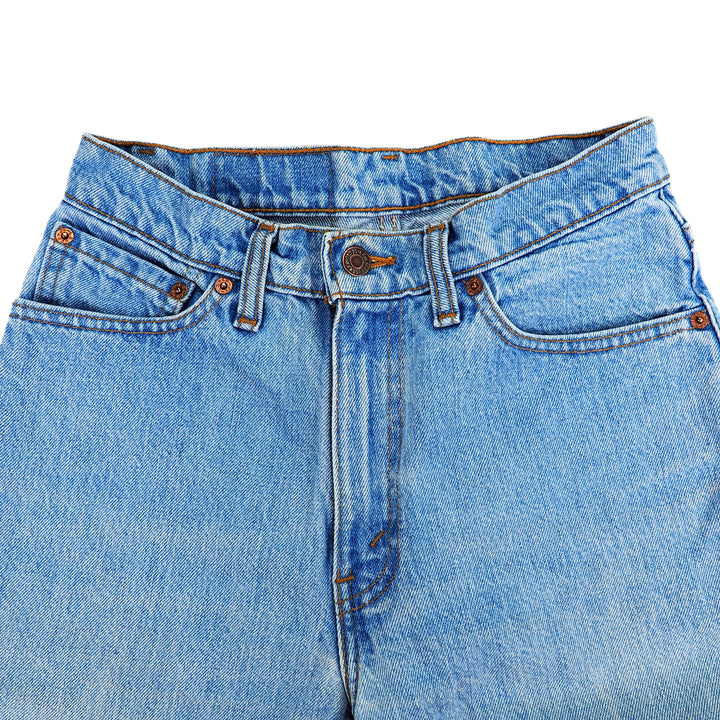Close-up of blue jeans focusing on the front pockets, fly and waist area on a white background