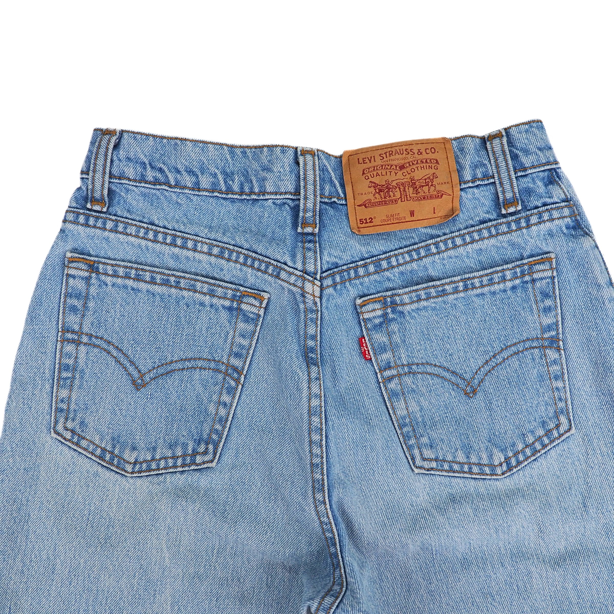 Back view of Levi's jeans focusing on the back pockets and brown jarcon tag on a white background