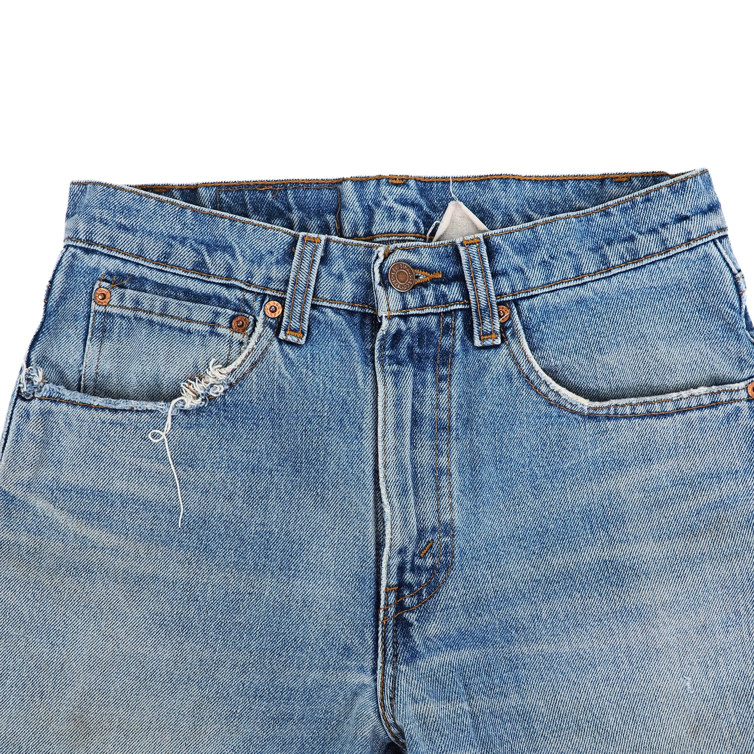 Close-up of a pair of blue jeans with a frayed pocket on a white background