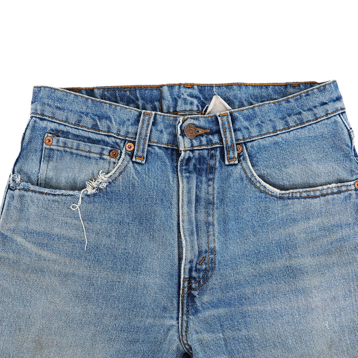Close-up of a pair of blue jeans with a frayed pocket on a white background