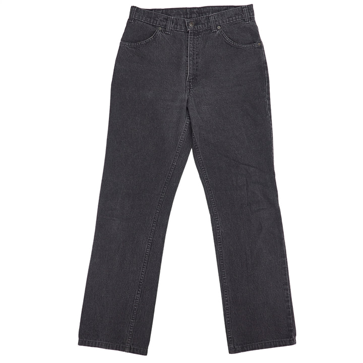 Front view of a pair of black denim jeans on a white background