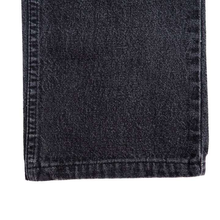 Close-up of dark gray denim jean pant leg with visible stitching on a white background