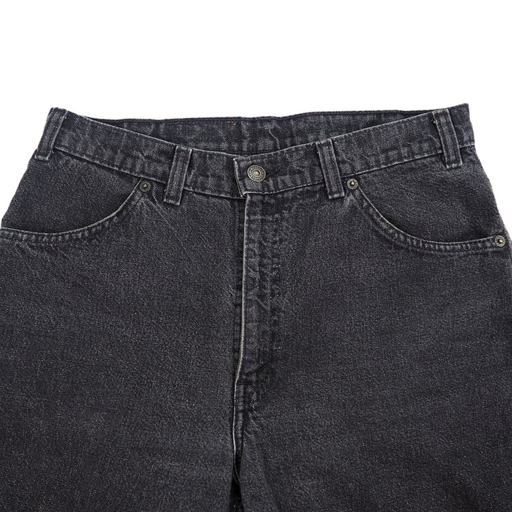 Close-up of black jeans waist area with a white background