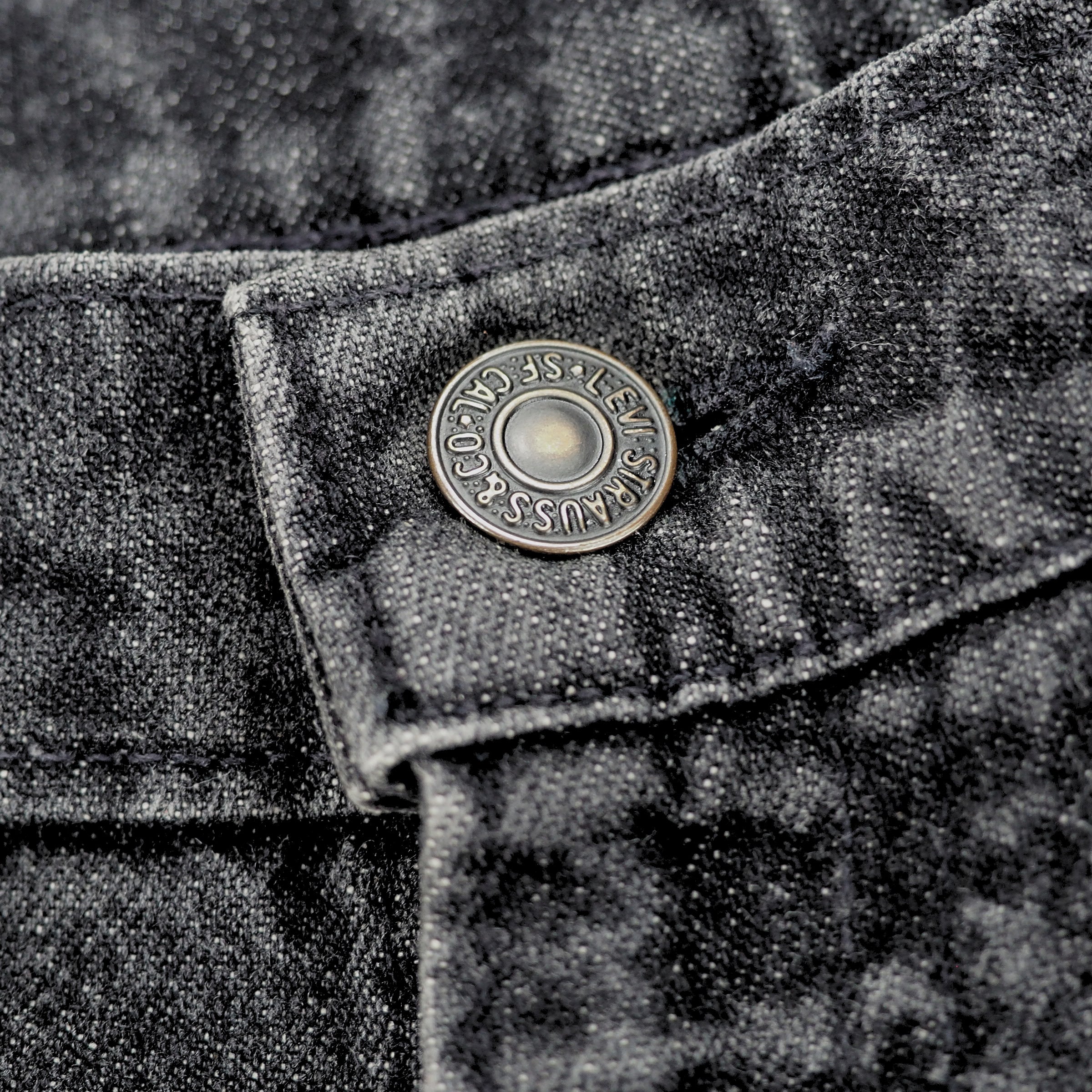 Close-up of a textured fabric with a button featuring 'Levi Strauss & Co.' branding.