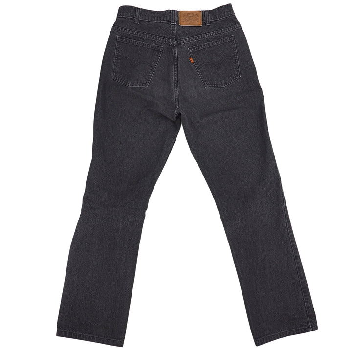 Rear view of a pair of black denim Levi's jeans on a white background