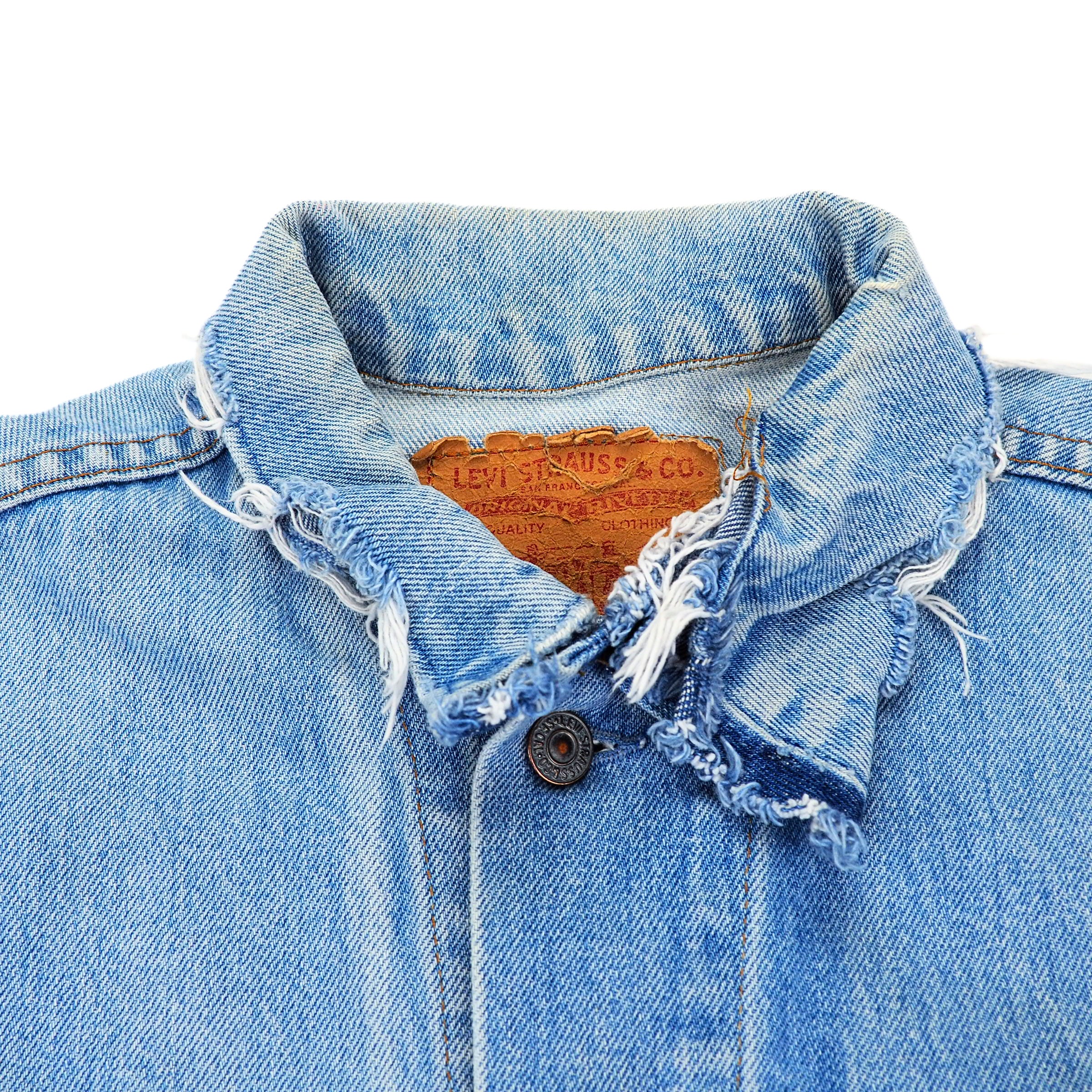 Close-up of a blue denim jacket with frayed collar and Levi's branding.