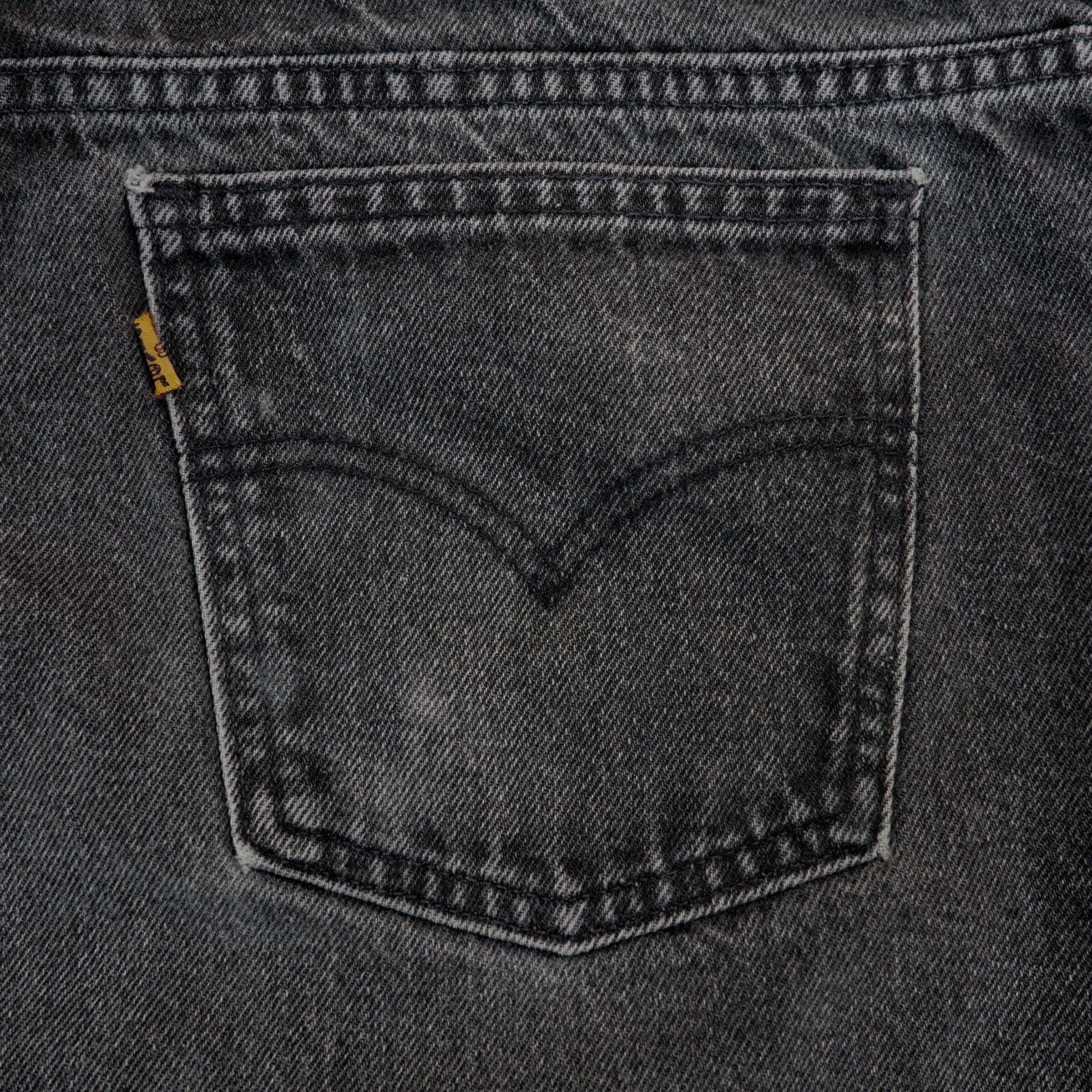 Close-up of a pocket on a gray denim fabric with a brand label.