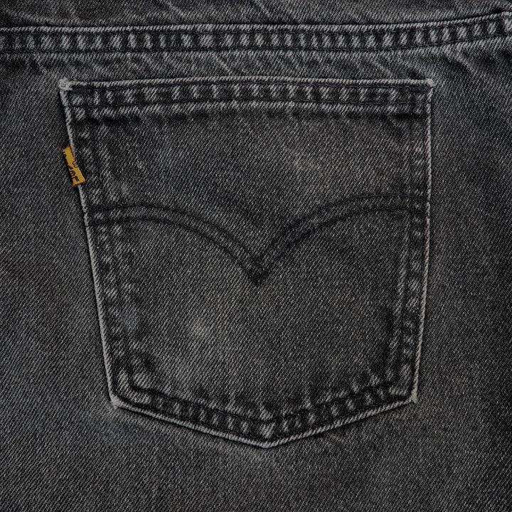 Close-up of a pocket on a gray denim fabric with a brand label.