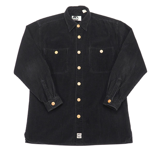A black corduroy button-down shirt jacket with light brown buttons, featuring two chest pockets and a classic collar, laid flat against a white background.