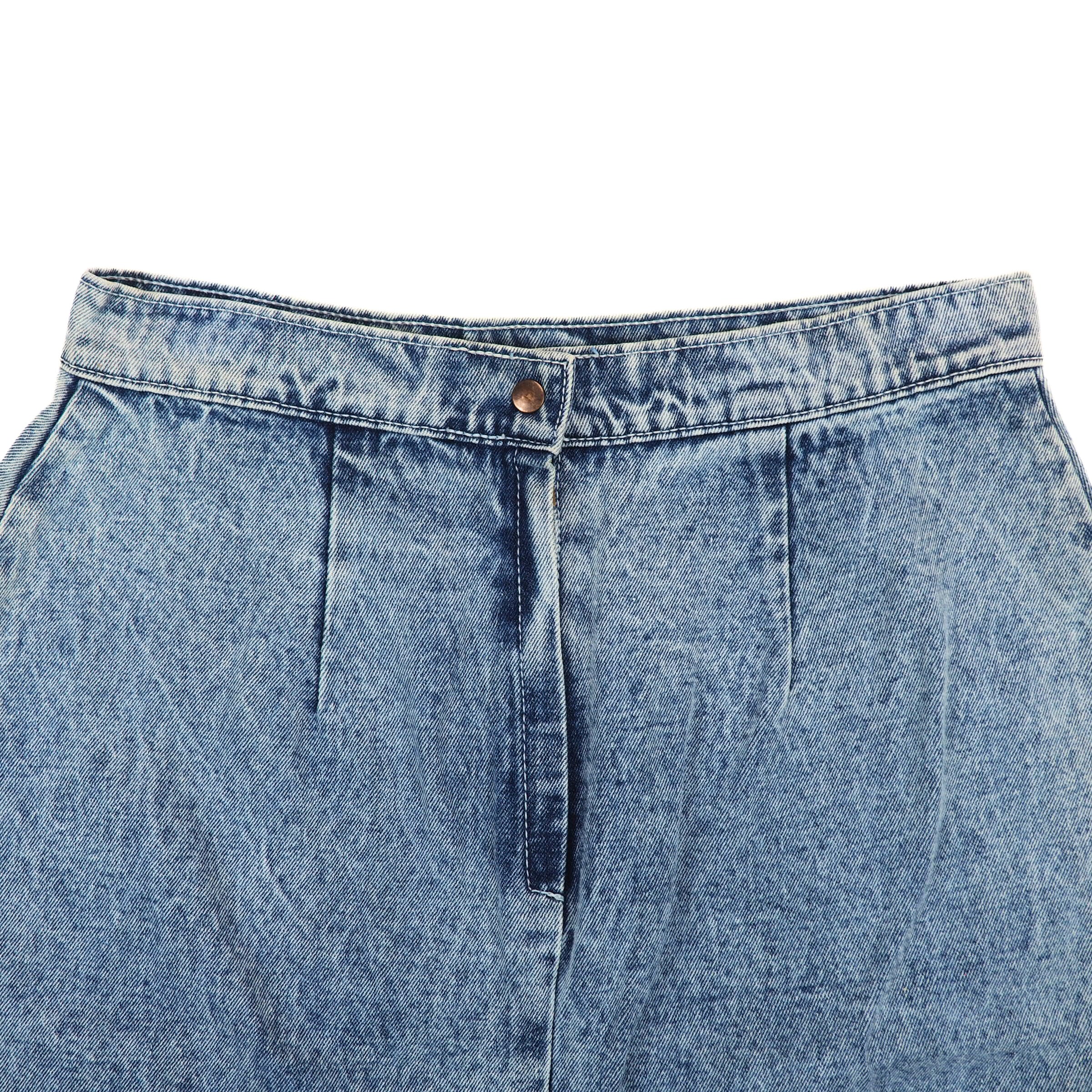 Close-up of the waist of a blue denim skirt on a white background