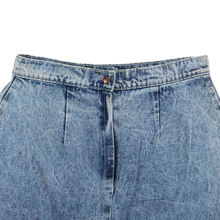 Close-up of the waist of a blue denim skirt on a white background