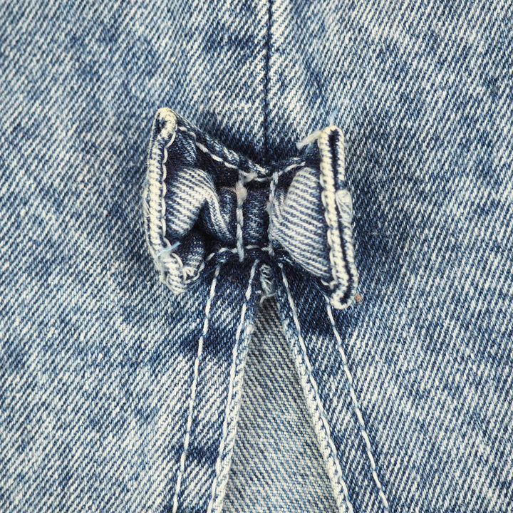Close up of a denim bow tie on a denim skirt.