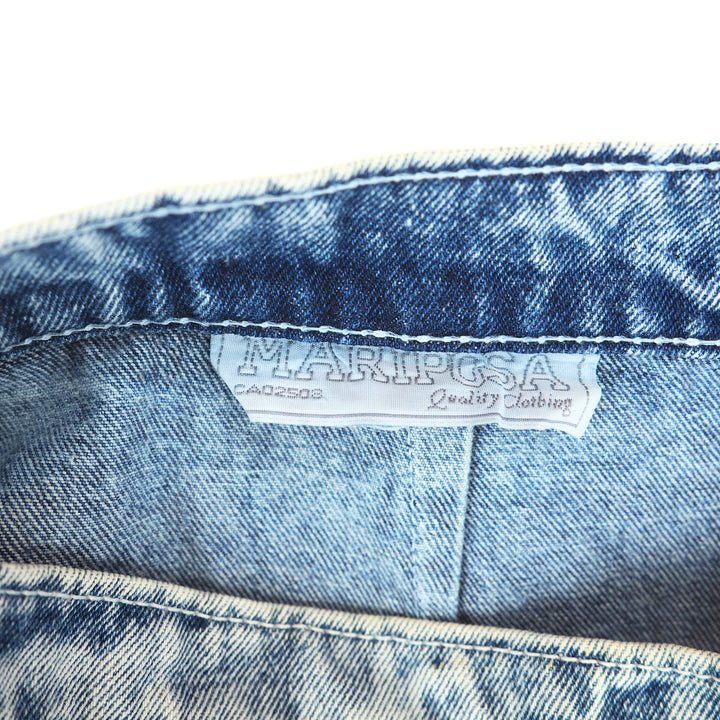 Close-up of a denim fabric with a 'Mariposa' label on a white background