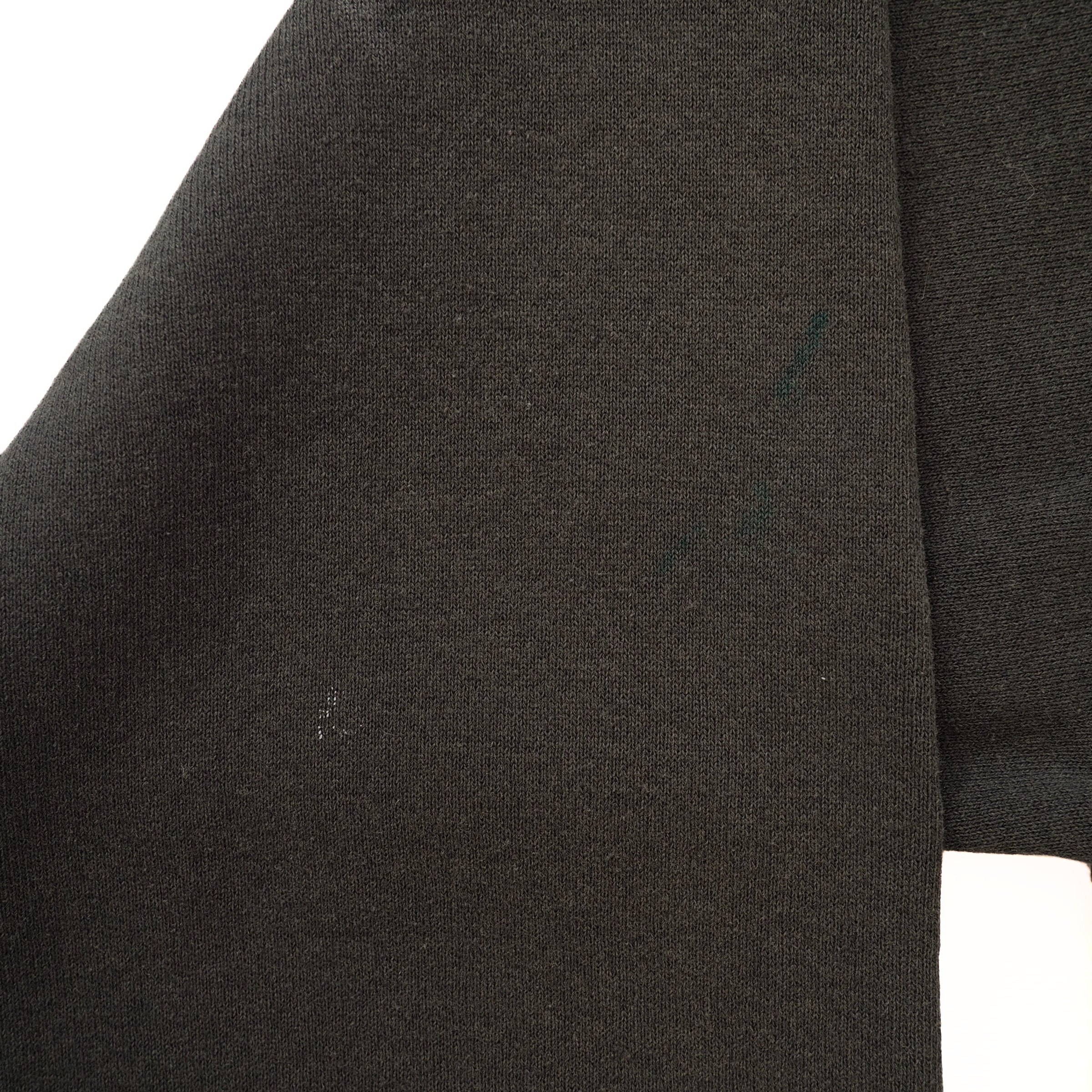 Close-up of a black gsweater sleeve on a white background
