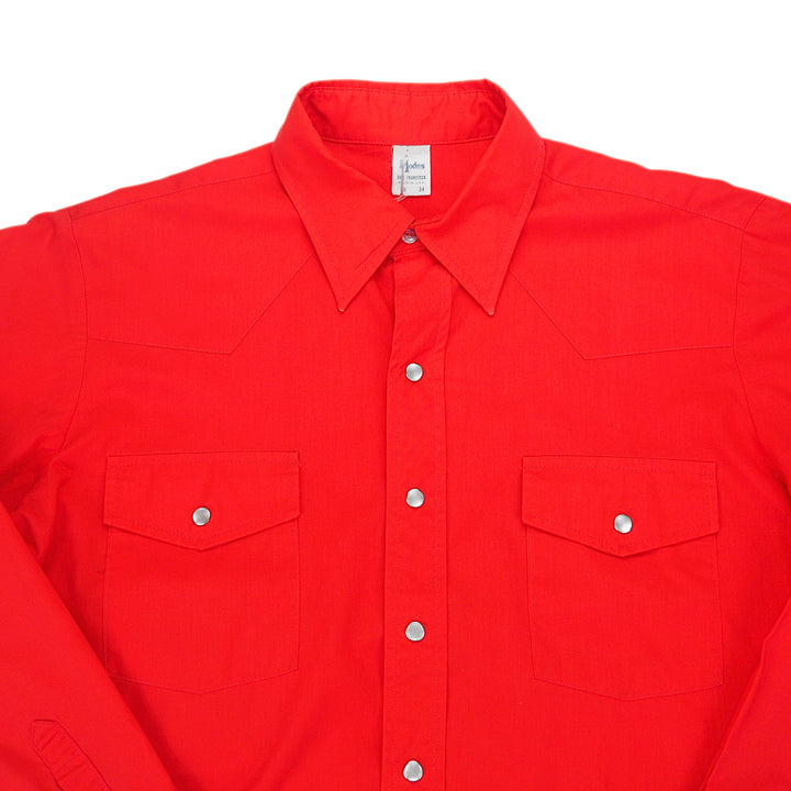 Detail of the chest and collar area of a red dress shirt with pearl snap buttons.
