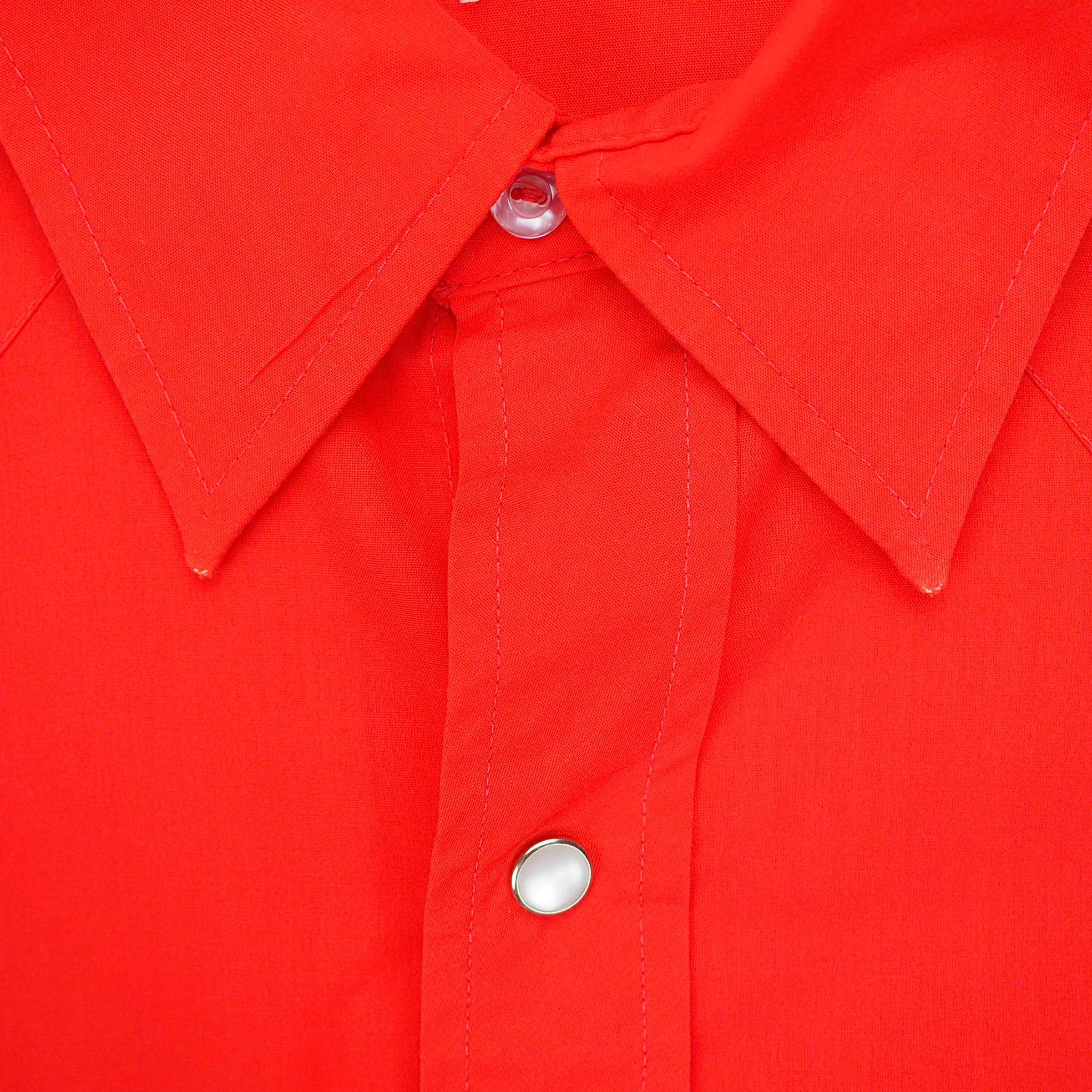 Close up of the collar of a red dress shirt.