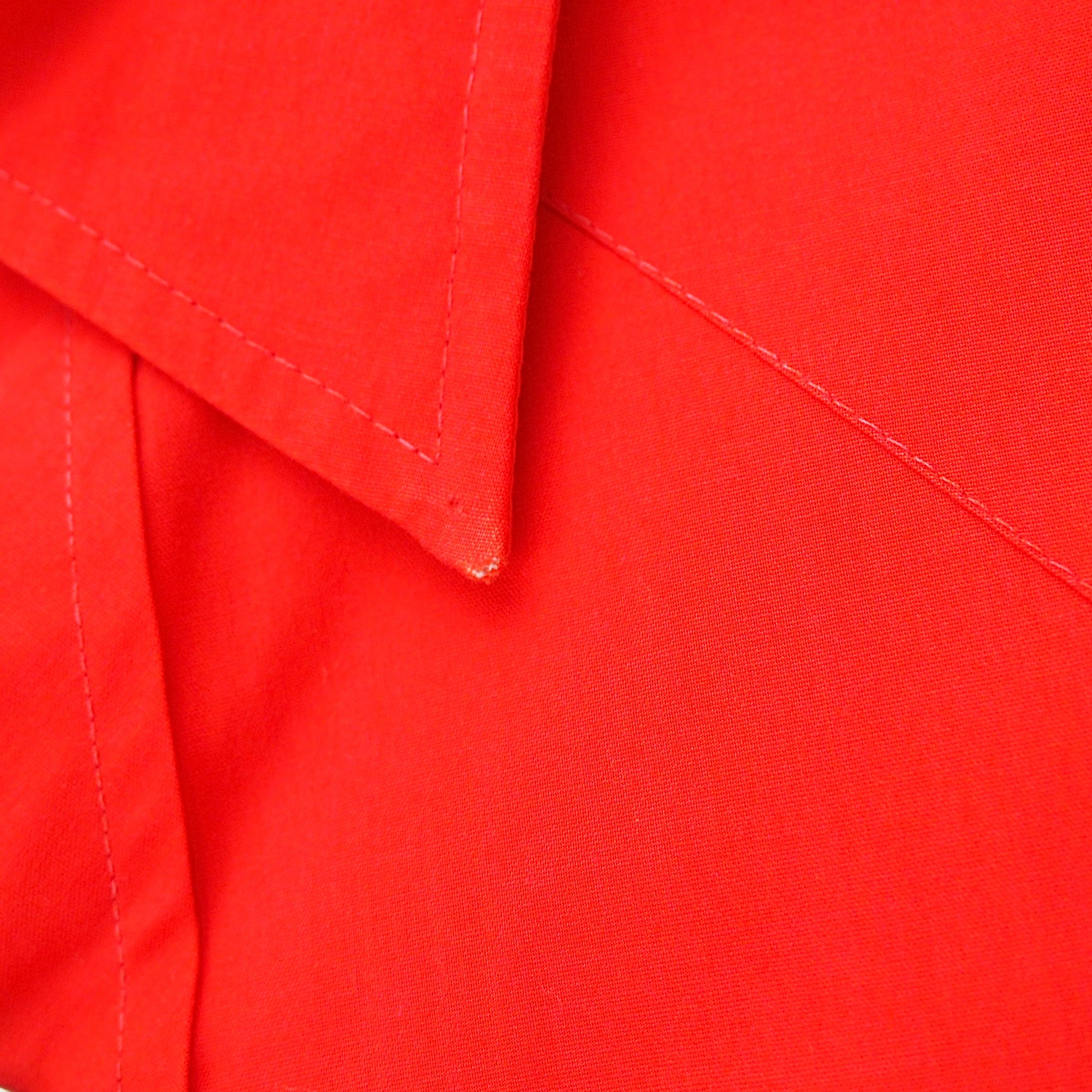 Close up of the collar of a red dress shirt.