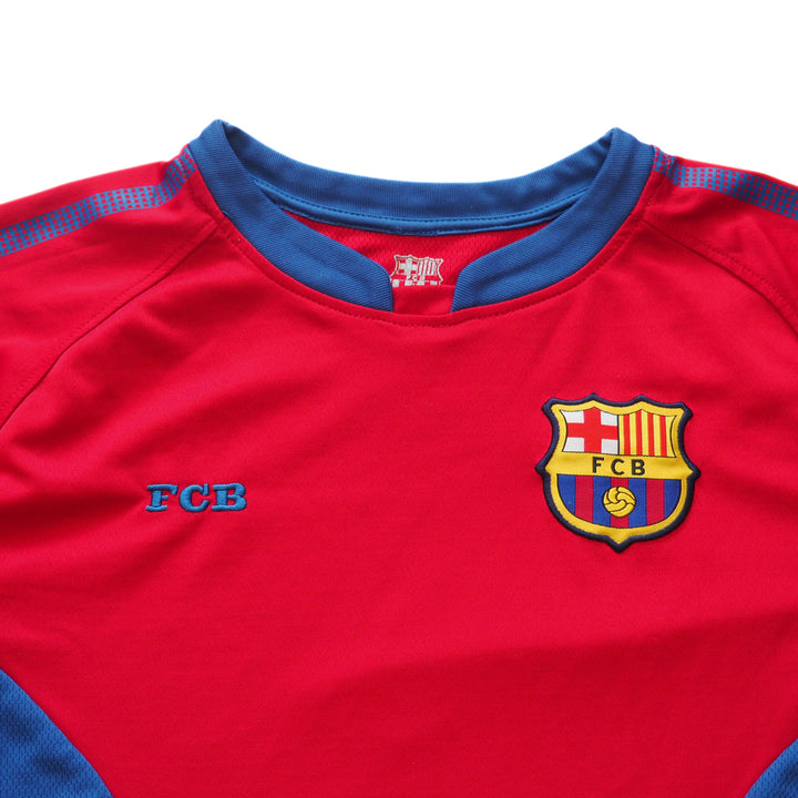 Chest and collar detail of a red FC Barcelona soccer jersey with blue accents and logos on a white background