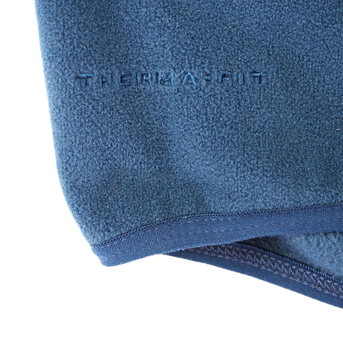 Close-up of a blue fleece fabric with the debossed brand name 'THERMAFIT' and a matching blue ribbed trim along the edge, shown on a white background.