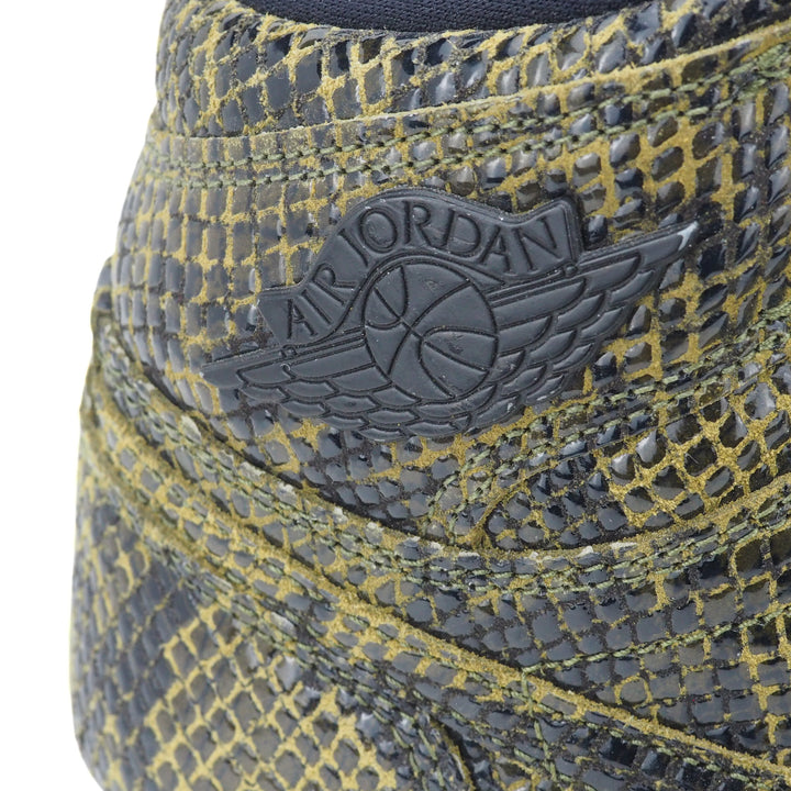 Close-up of an Air Jordan logo on a green and black textured snakeskin surface