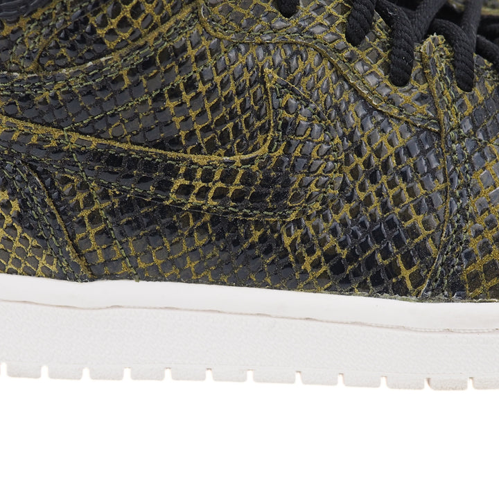 Close-up of the outside of a snakeskin sneaker with a Nike Swoosh on the side and a white midsole.