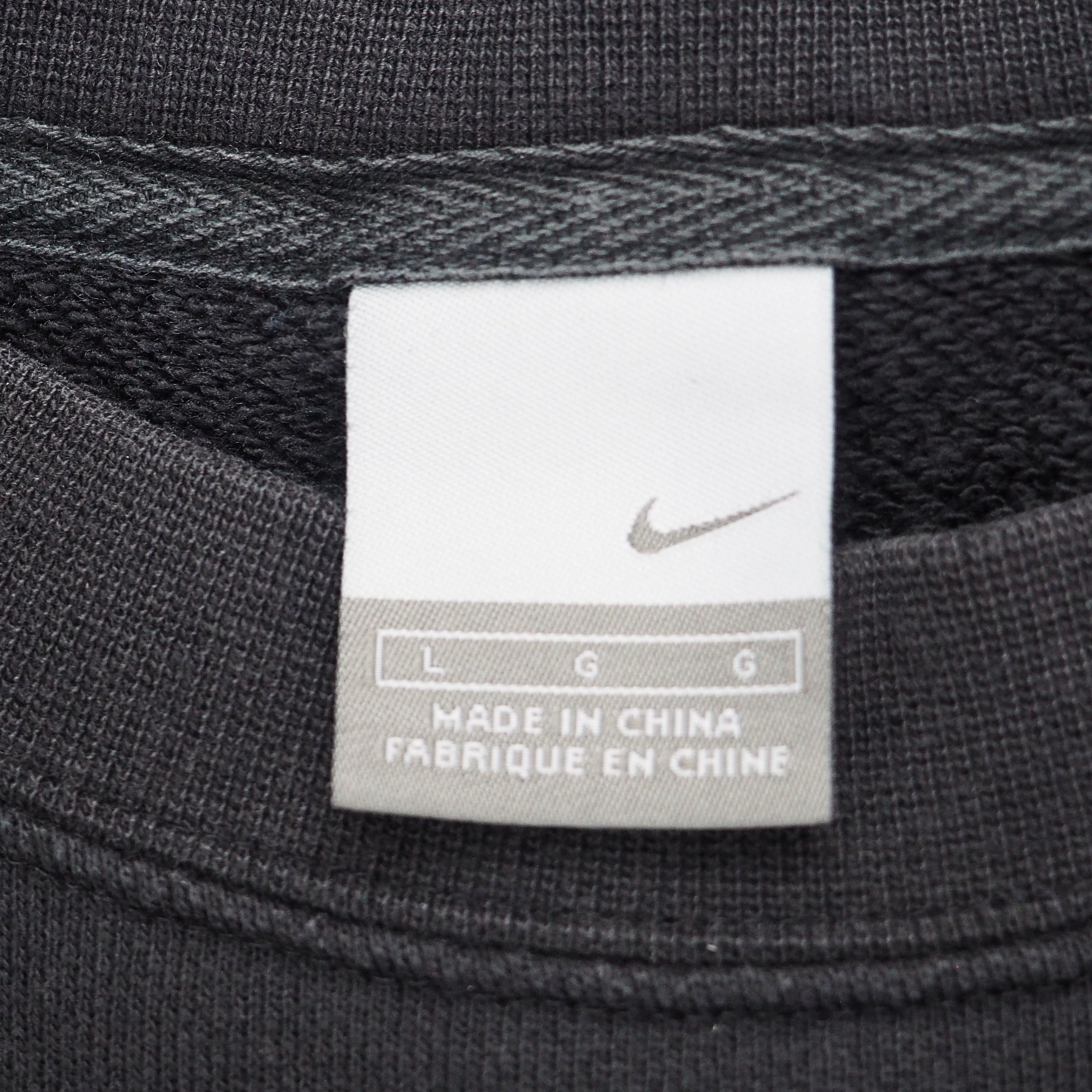 Close up of a Nike silver tag size label on a black sweatshirt