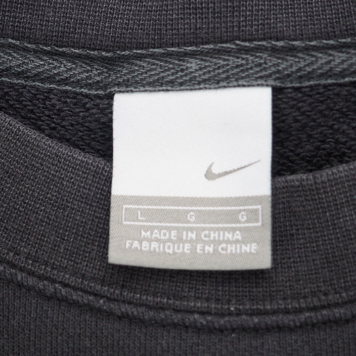 Close up of a Nike silver tag size label on a black sweatshirt