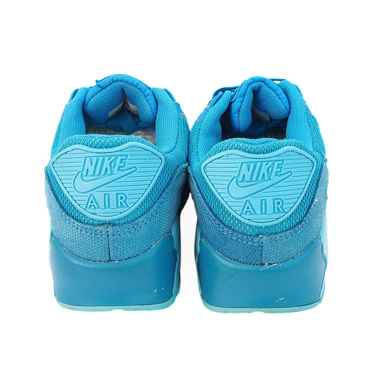 Back view of a pair of blue Nike Air shoes on a white background