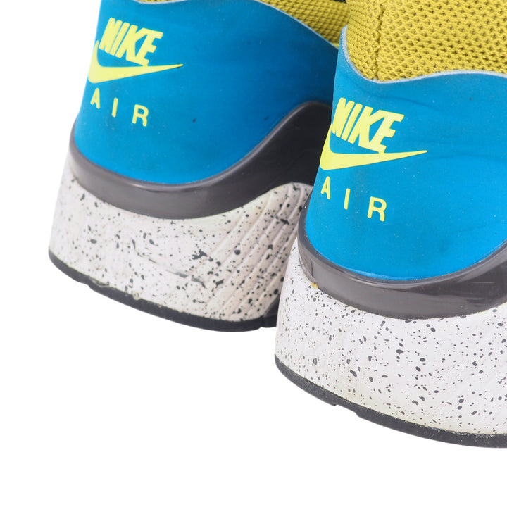 Close-up of blue and yellow Nike Air shoes with speckled sole.