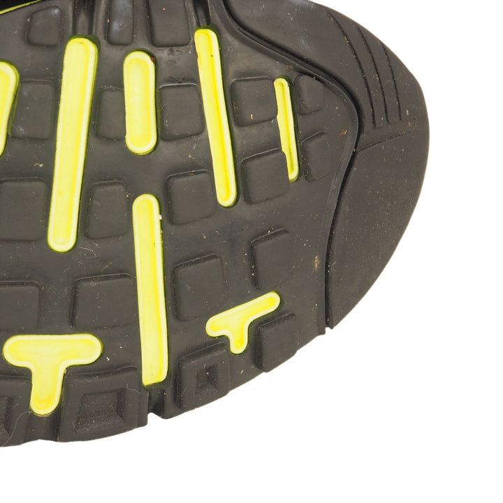 Close-up of a black and yellow sole of a running shoe