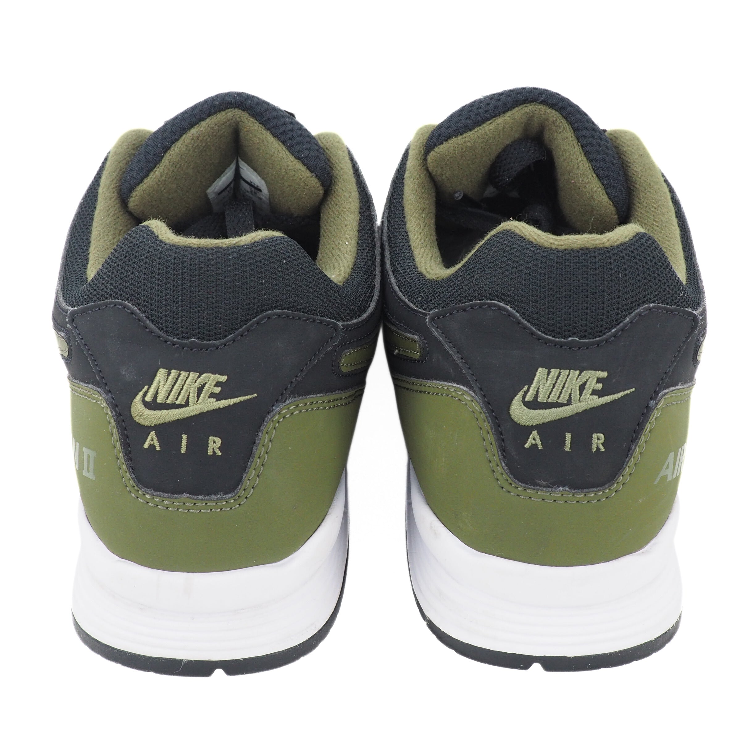 Back view of the heels of a pair of Nike Air sneakers with green and black design on a white background