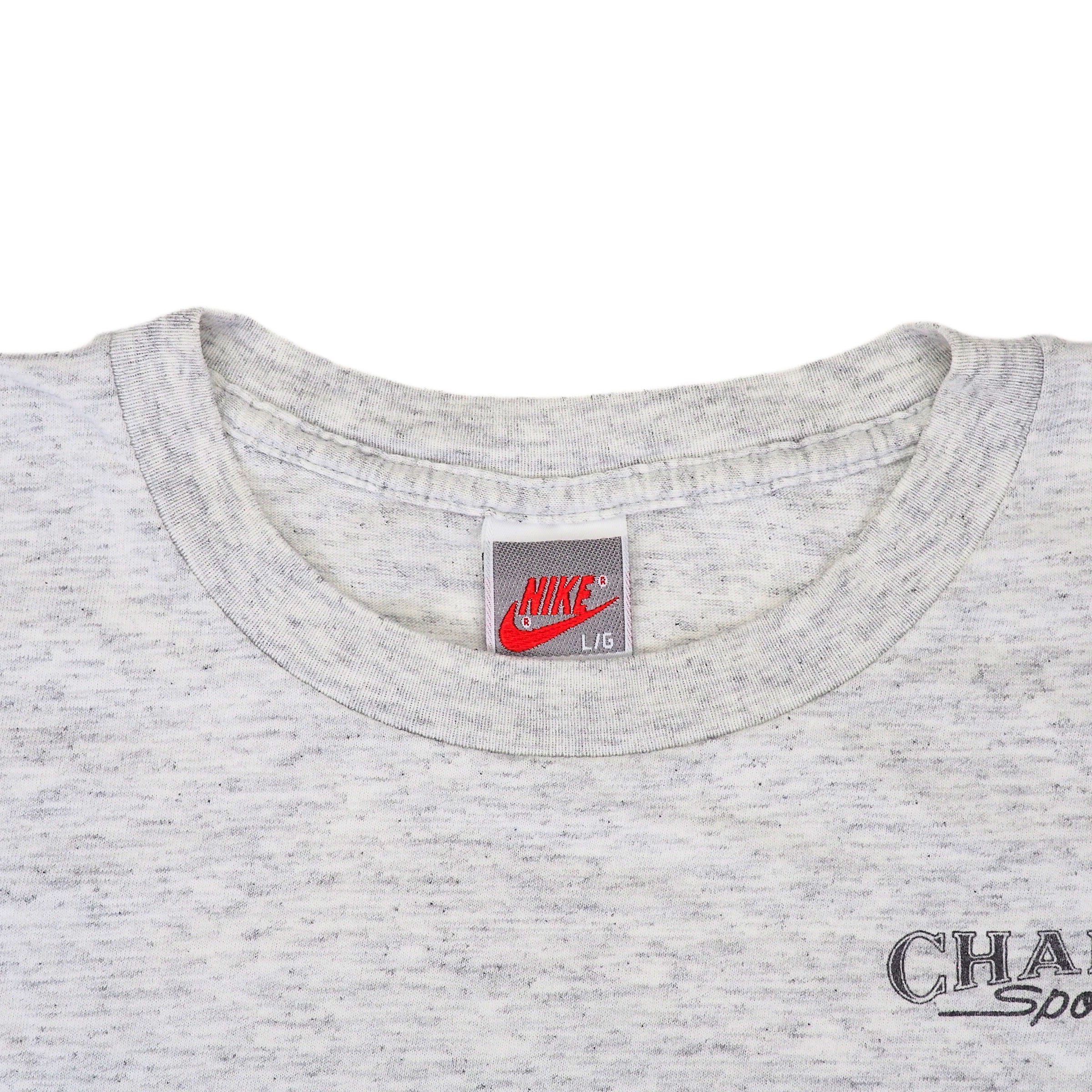 Close up of the collar of a vintage Nike t-shirt in grey on a white background