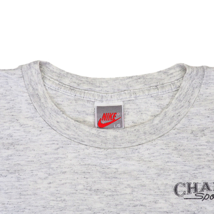Close up of the collar of a vintage Nike t-shirt in grey on a white background
