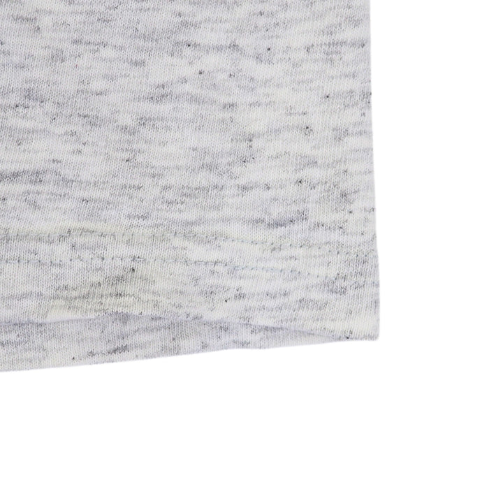 Close up of the hem of a heathered grey t-shirt on a white background