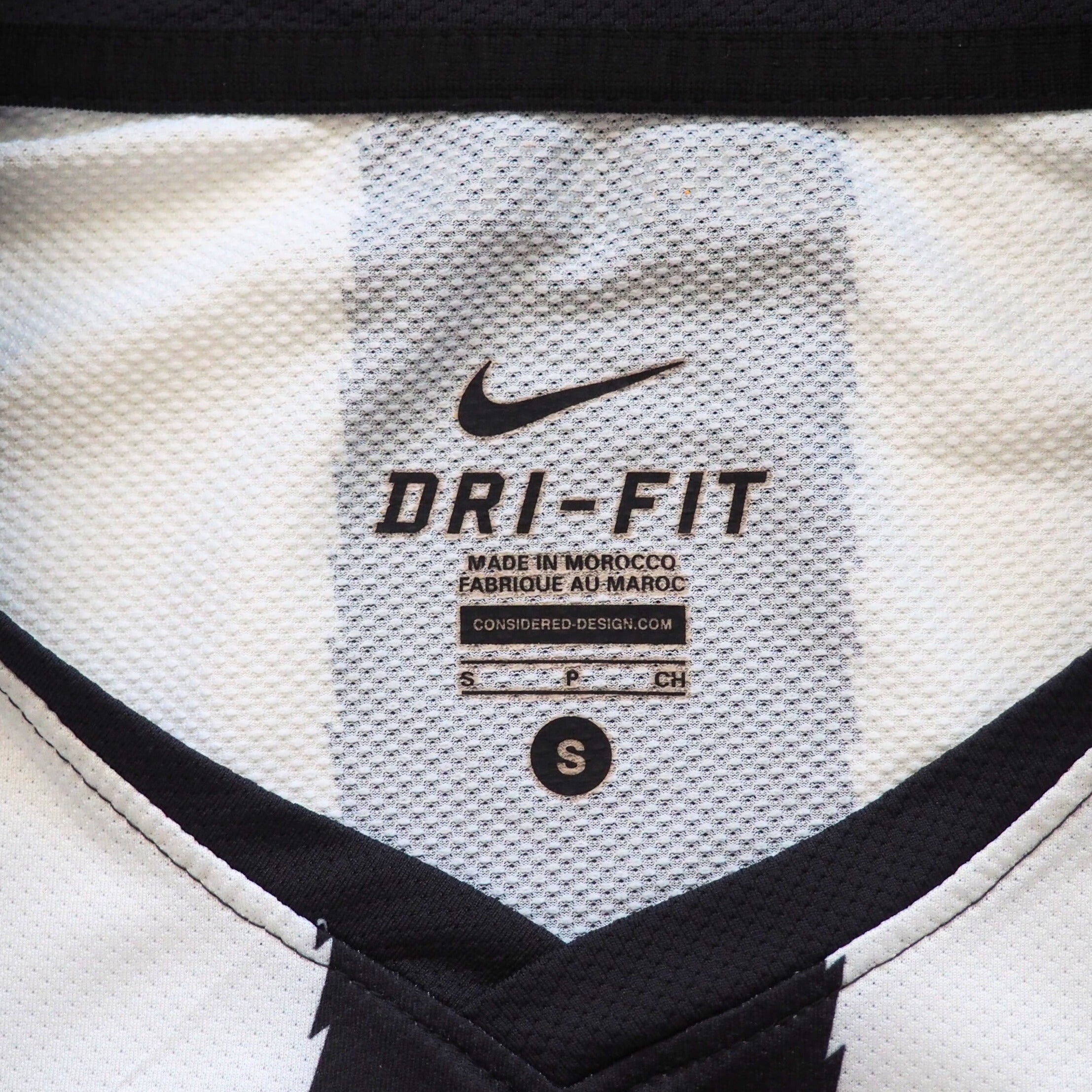 Close-up of a Dri-Fit label on a sports jersey with Nike branding.