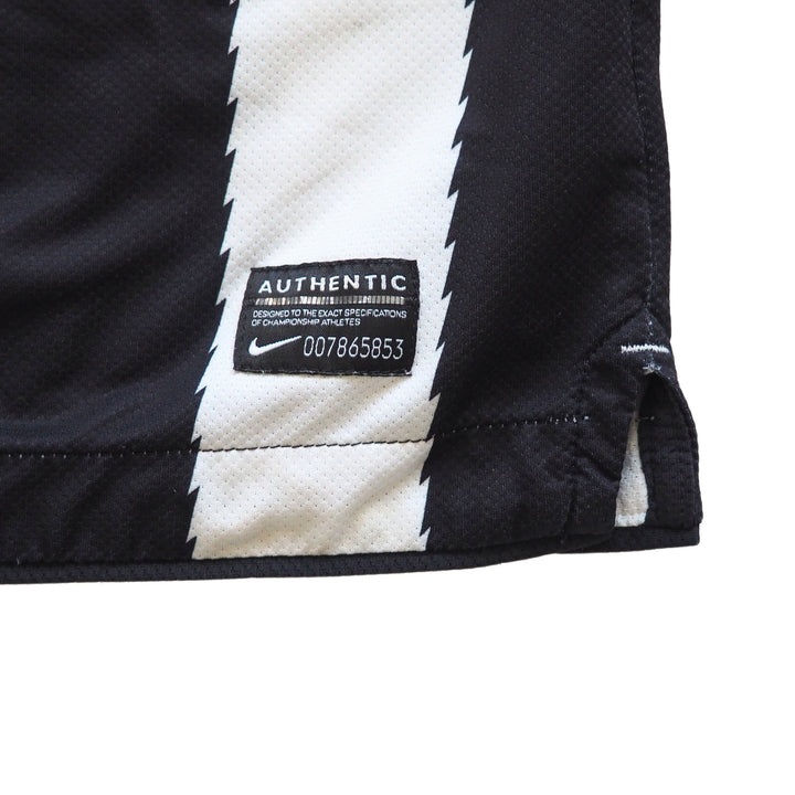 Close-up of a black and white Juventus soccer jersey with a numbered Nike 'Authentic' label on a white background