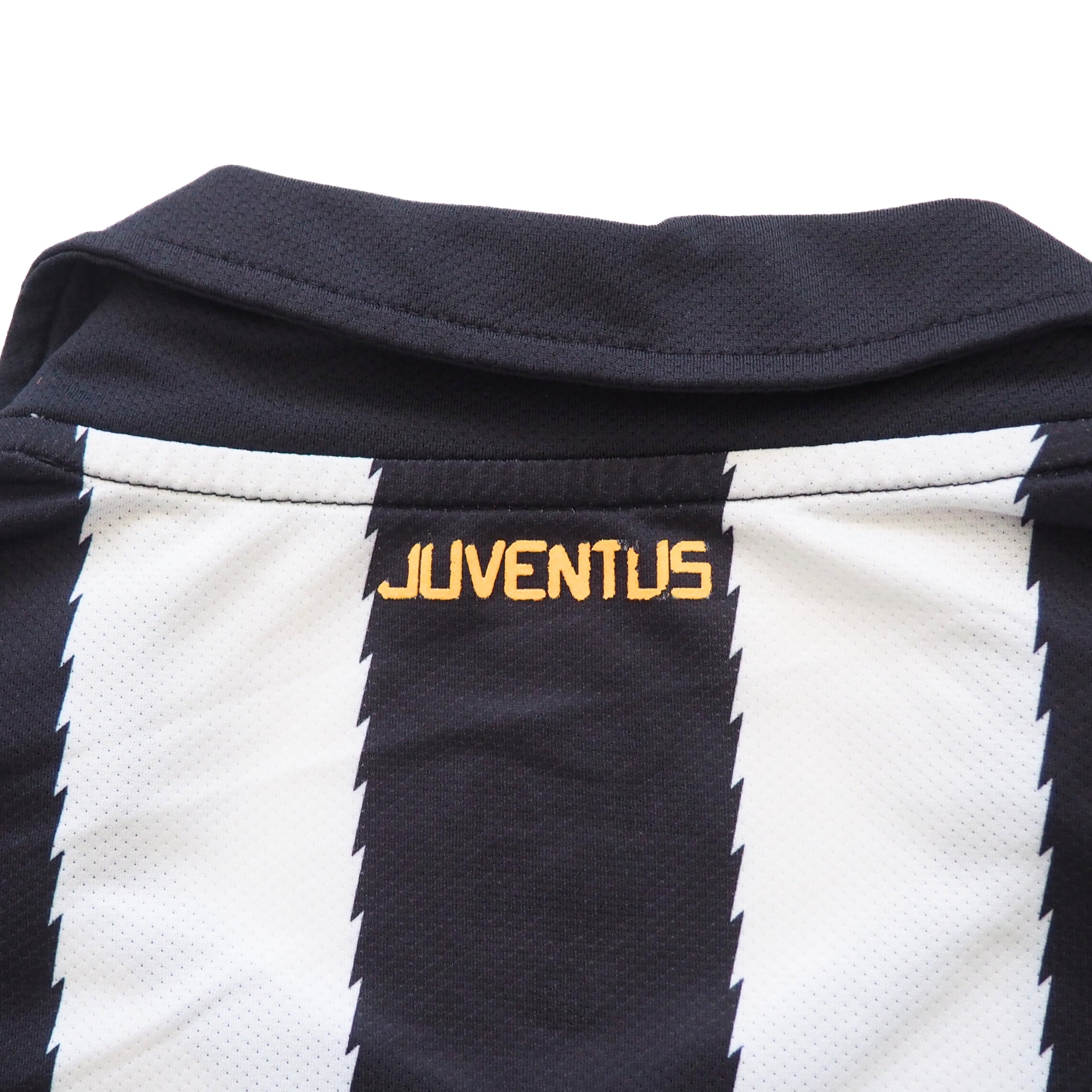 Close-up of the back collar of a black and white striped soccer jersey with 'Juventus' branding on a white background.