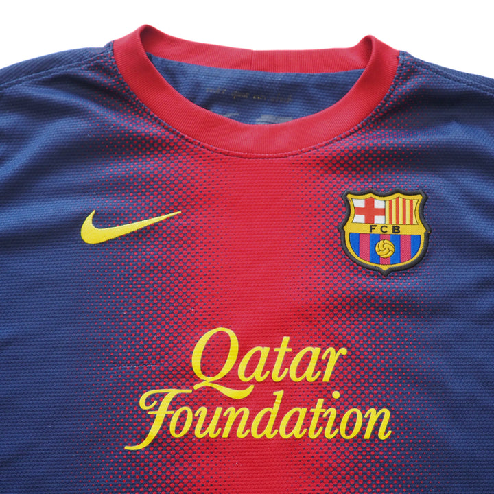 Close-up detail of chest and collar of a blue and red soccer jersey with a Nike logo and FC Barcelona emblem.