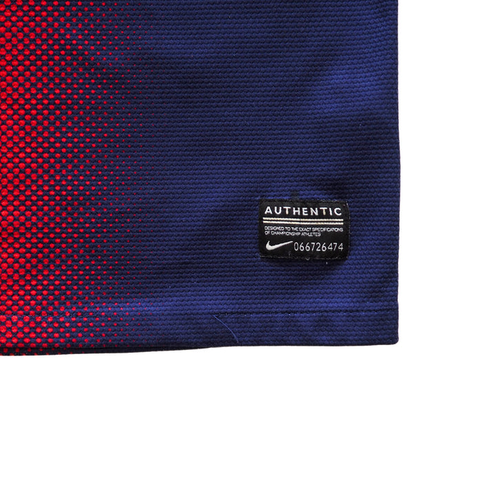 Close-up of a blue and red textured fabric with a numbered 'Authentic Nike' label.