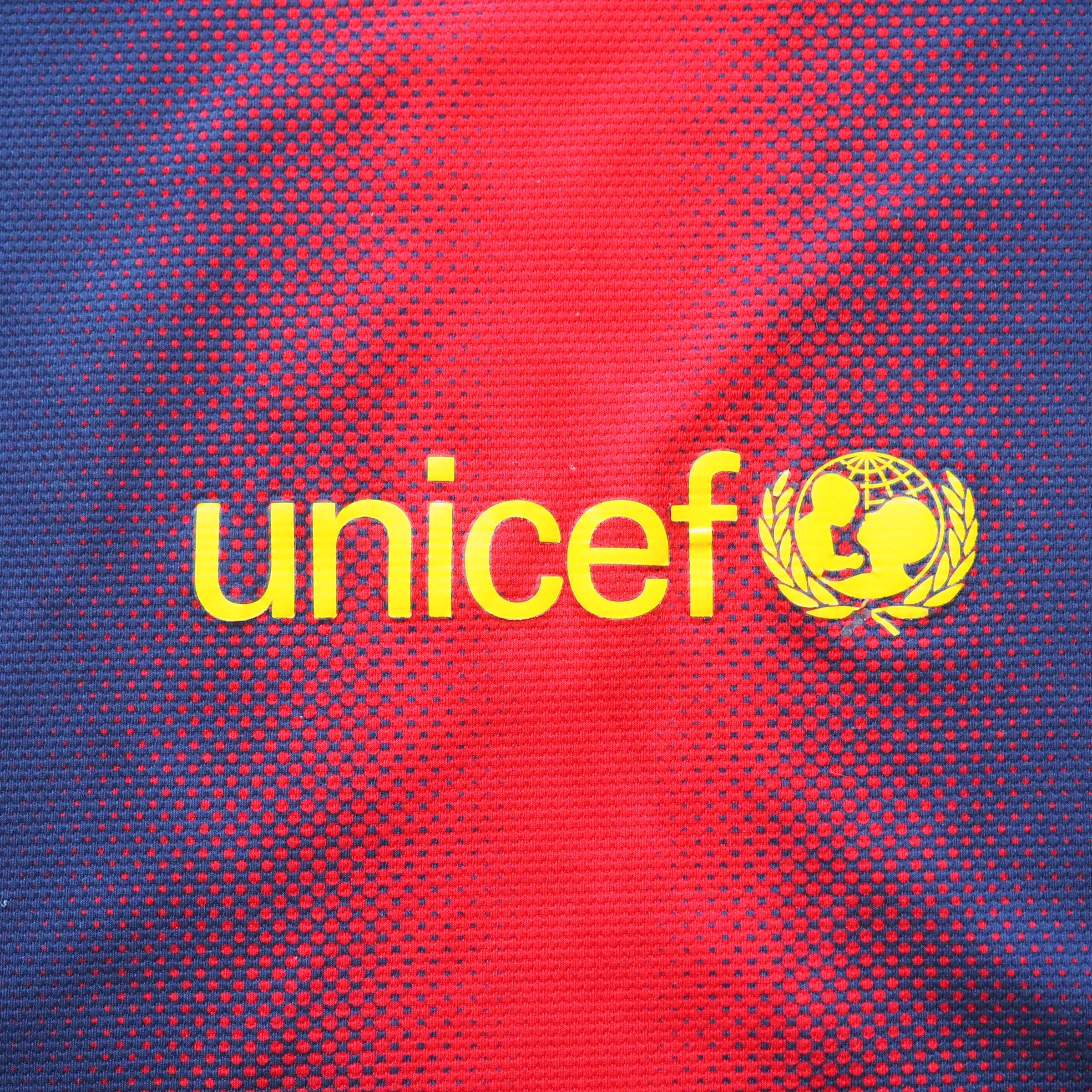 Yellow UNICEF logo on a red and blue patterned background