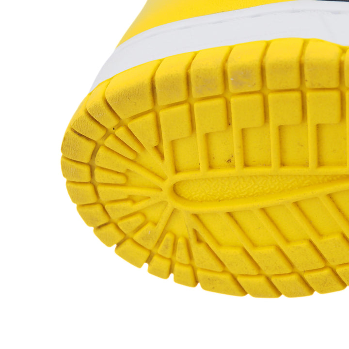 Close-up of a yellow shoe sole with white midsole on a white background