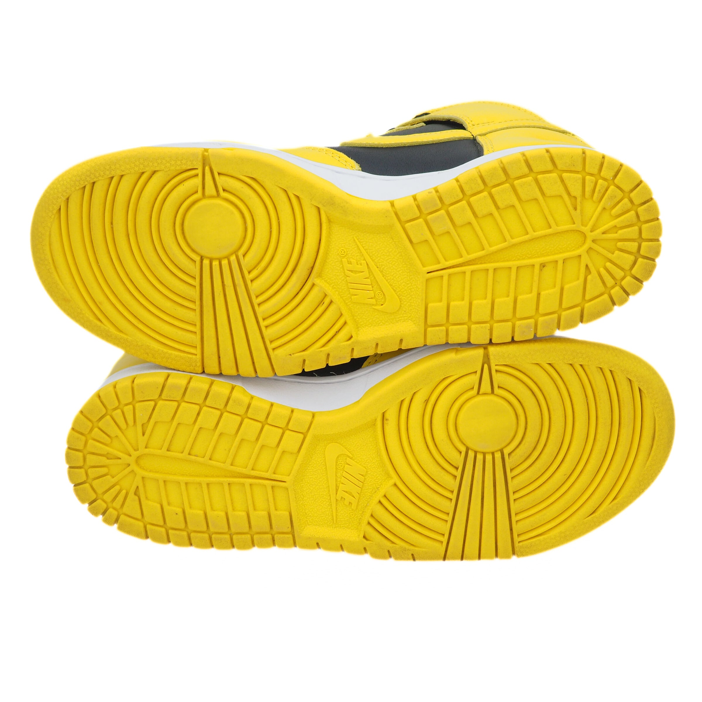 Yellow and black sneakers with a focus on the sole on a white background
